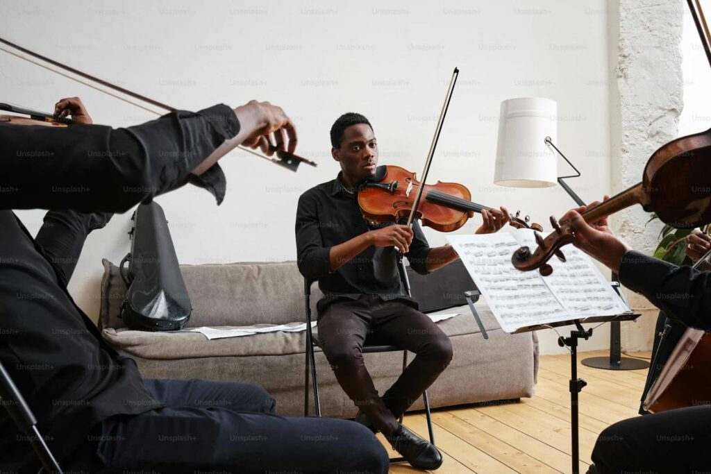 People playing music together using sheet music — courtesy of Andrej Lišakov.